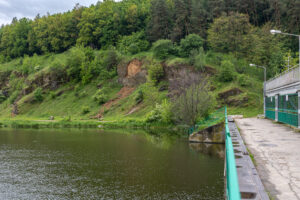Rocky mountains covered with potion near the bridge over the river.